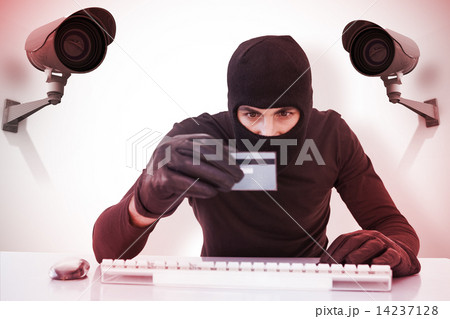 Composite image of burglar doing online shopping with laptop and Composite image of burglar doing online shopping with laptop and 14237128