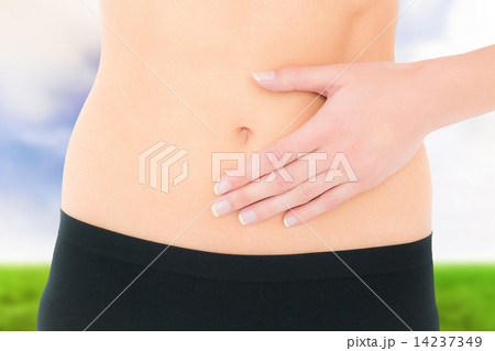 Composite image of closeup mid section of a fit woman with stoma 14237349