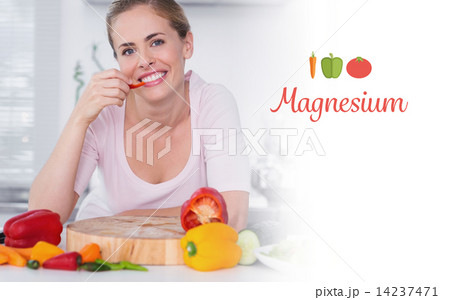 Magnesium against cheerful woman eating vegetables 14237471