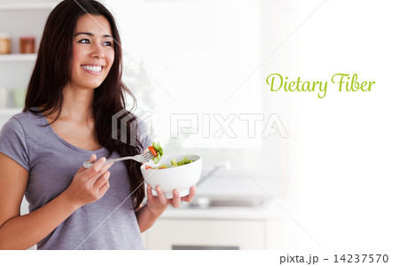 Dietary fiber against attractive woman enjoying a bowl of salad 14237570