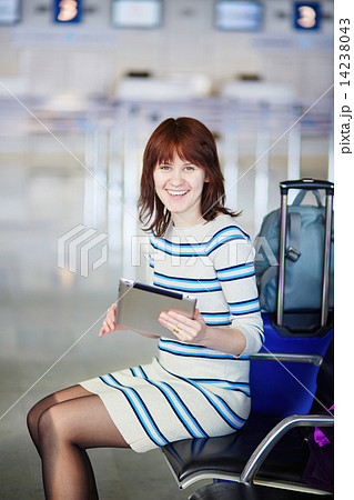 Young passenger at the airport, using her tablet Young passenger at the airport, using her tablet 14238043