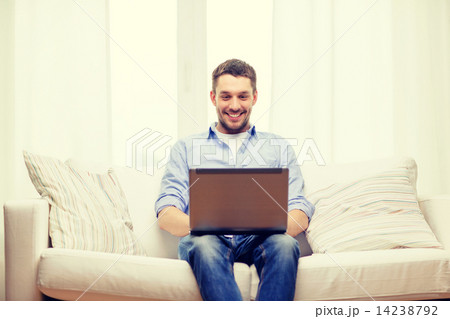smiling man working with laptop at home smiling man working with laptop at home 14238792