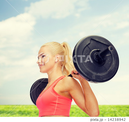smiling sporty woman exercising with barbell smiling sporty woman exercising with barbell 14238942