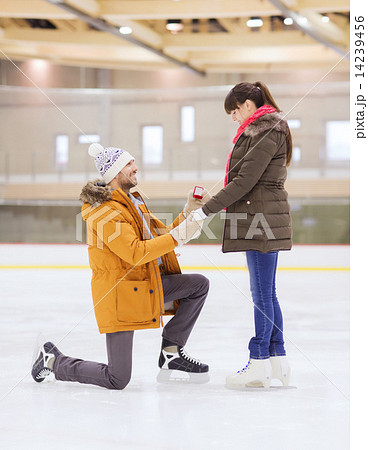 happy couple with engagement ring on skating rink 14239456