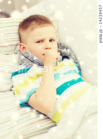 ill boy with scarf lying in bed and coughing ill boy with scarf lying in bed and coughing 14239457