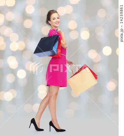 young happy woman with shopping bags over lights 14239861
