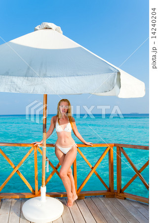 Young woman on a water villa terrace , Maldives Young woman on a water villa terrace , Maldives 14240204