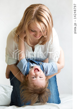 mother and her kid lying on the bed and smiling mother and her kid lying on the bed and smiling 14248797