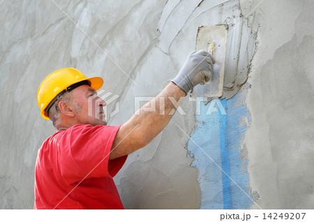 Wall insulation, spreading mortar over mesh 14249207