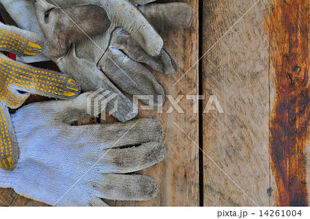 Old safety gloves on wooden background, Gloves on dirty works. 14261004
