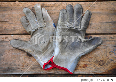 Old safety gloves on wooden background, Gloves on dirty works. 14261019