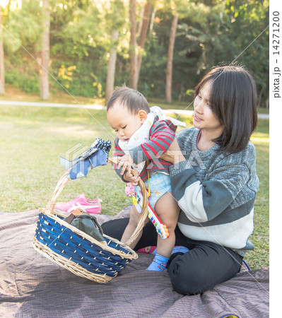 Mother holding baby when family picnic in the park Mother holding baby when family picnic in the park 14271200