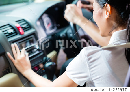 Asian couple driving new car, she is turning on the radio 14275957