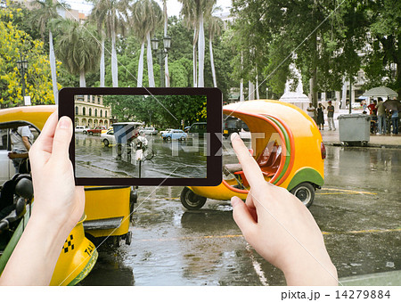 tourist taking photo of Havana street in rain 14279884