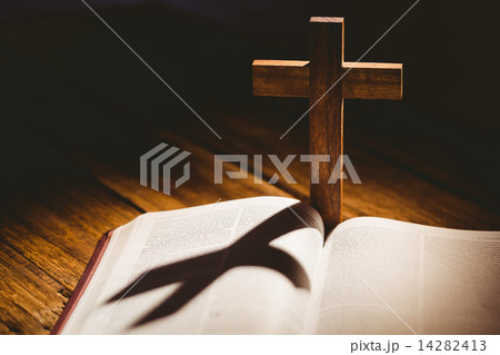 Open bible with crucifix icon behind 14282413