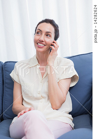 Casual brunette using phone on couch 14282624