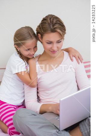 Mother and daughter using laptop in bed Mother and daughter using laptop in bed 14283225