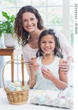 Happy mother and daughter painting easter eggs 14283226