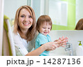 Happy mother and child washing hands with soap in bathroom 14287136