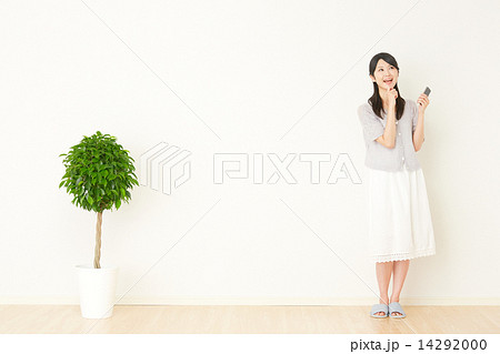 部屋でスマートフォンを持って想像する女性 部屋でスマートフォンを持って想像する女性 14292000