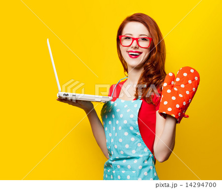 Young housewife with computer and oven gloves 14294700