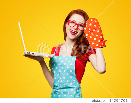 Young housewife with computer and oven gloves 14294701