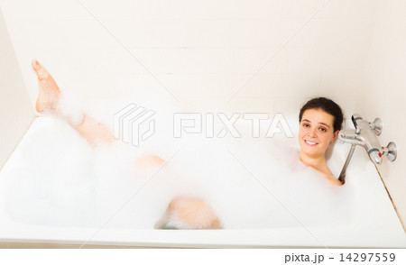 young girl laying with foam in bath 14297559