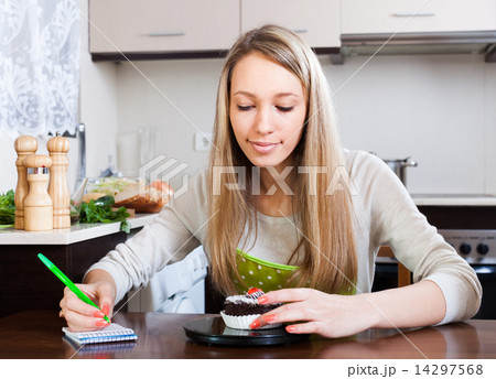 girl weighing cakes on kitchen scales 14297568