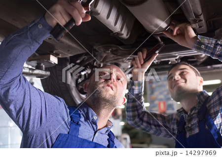 Two car mechanics at workshop 14297969