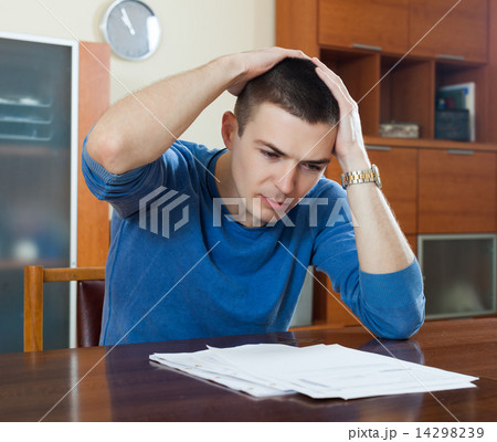 man fills in financial documents 14298239