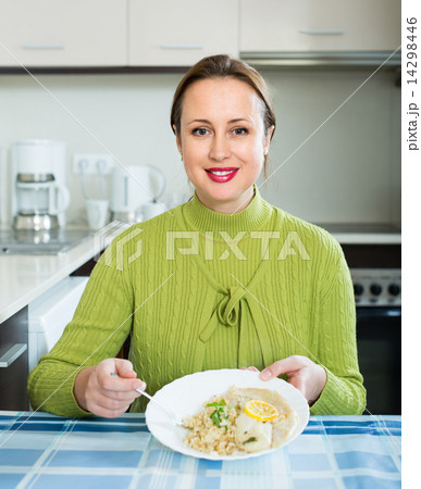 Woman eating at kitchen Woman eating at kitchen 14298446