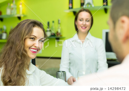 Female barista and two clients in cafe Female barista and two clients in cafe 14298472
