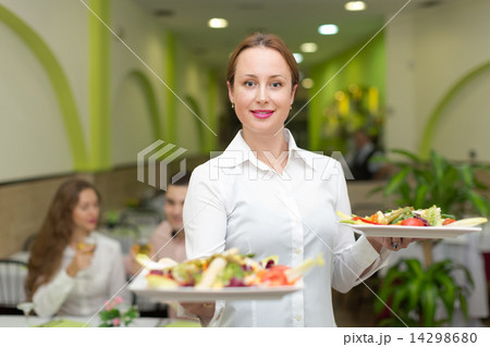 Female waiter serving guests table Female waiter serving guests table 14298680