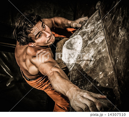 Muscular man practicing rock-climbing on a rock wall indoors Muscular man practicing rock-climbing on a rock wall indoors 14307510