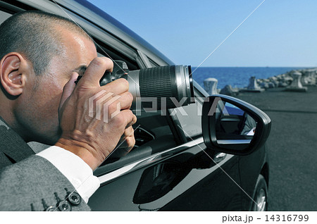 detective or paparazzi taking photos from inside a car 14316799