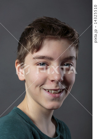 portrait of a smiling teenage boy, with gray background for fast 14325510