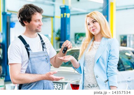 Workshop mechanic handing car to customer 14357534