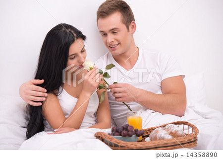 Man giving rose to his wife while having breakfast in bed Man giving rose to his wife while having breakfast in bed 14358890