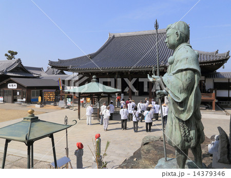 四国霊場第76番札所「金倉寺」智証大師像と本堂にお参りするお遍路さん 14379346