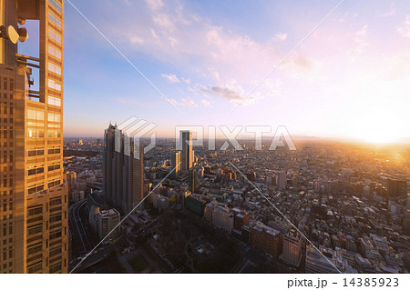 新宿高層ビルから超広角で望む 夕焼けの日没 東京街並全景 南西の方角 強烈な太陽光線 遥か彼方横浜の写真素材