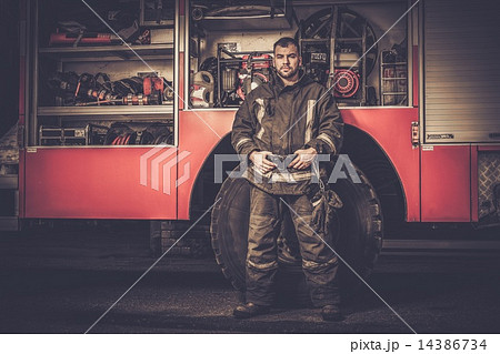 Firefighter near truck with equipment Firefighter near truck with equipment 14386734