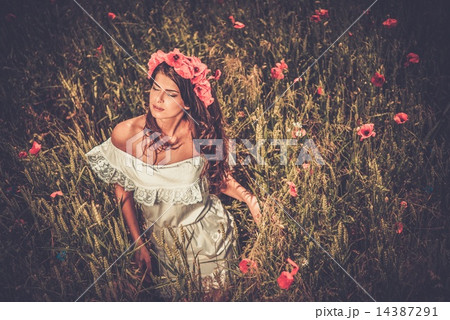 Brunette girl wearing white summer dress and flower chaplet in poppy filed 14387291