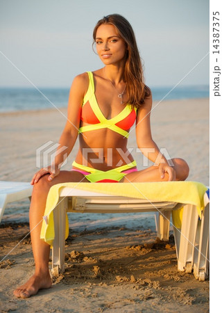 Young girl in swimming suit on a beach Young girl in swimming suit on a beach 14387375