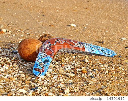 Boomerang and coconut on a sand. 14391912