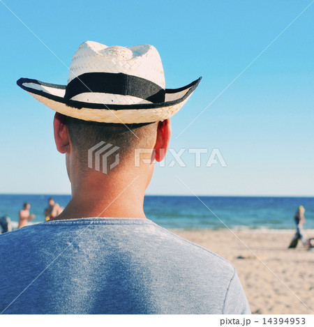 young man with a straw hat on the beach 14394953