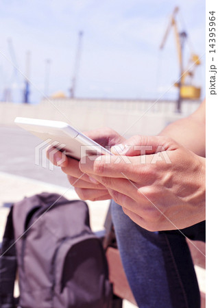 young man using a tablet or an e-book outdoors 14395964