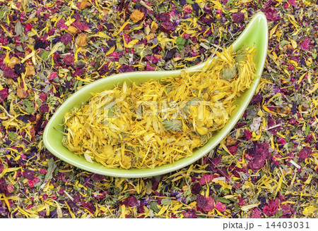 Dry calendula in green bowl with herbal tea around Dry calendula in green bowl with herbal tea around 14403031