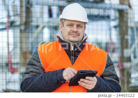 Electrical Engineer with tablet PC near the electr 14403122