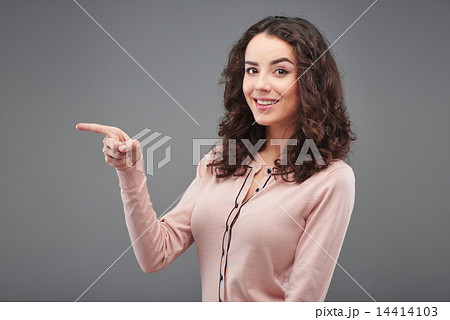 Beautiful young woman pointing at something 14414103