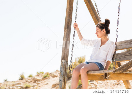 Young black hair woman sitting on the swing 14414716